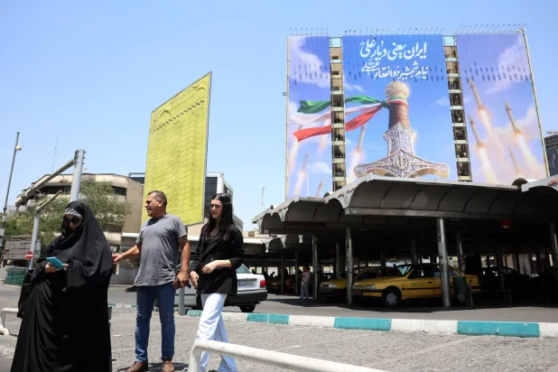 إيرانيون يمرون أمام لوحة إعلانية سياسية في طهران - إيران 11 يونيو 2026 (إ.ب.أ)
