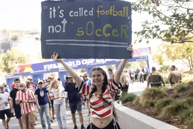 A USA fan holds a sign as she arrives at Los Angeles Stadium (SoFi Stadium) to attend the 2026 FIFA World Cup match between USA and Paraguay in Inglewood, California, on June 12, 2026. ETIENNE LAURENT / AFP
