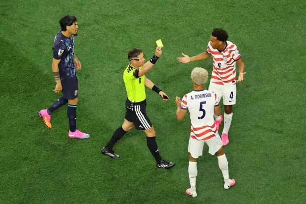 تيم ريم مدافع المنتخب الأميركي يتلقى الإنذار الذي سحب فيما بعد (رويترز)