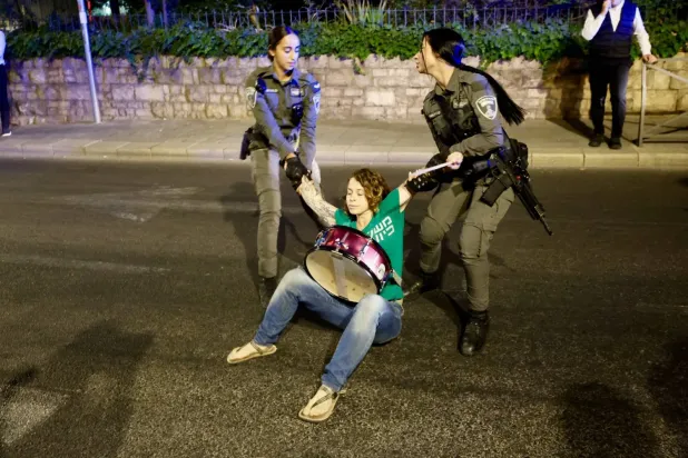 Cumartesi günü, İsrail Başbakanı Binyamin Netanyahu’nun Kudüs'teki konutunun yakınlarında hükümetini protesto eden bir göstericiyi gözaltına alan iki İsrailli kadın polis memuru (DPA)