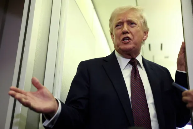 US President Donald Trump speaks to reporters aboard Air Force One on a flight back to Washington March 15, 2026. REUTERS/Kevin Lamarque/File Photo