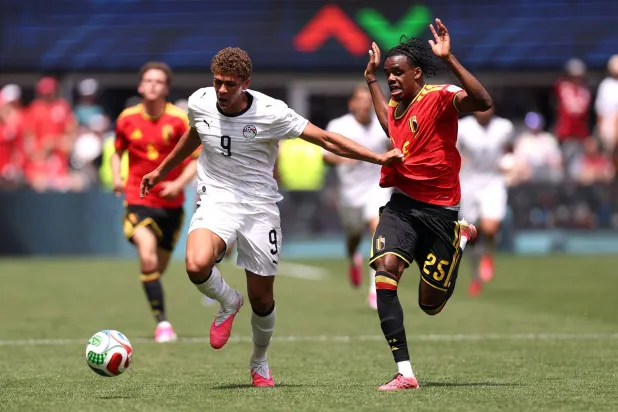 حمزة عبد الكريم في سباق بالكرة مع ناثان نغوي لاعب بلجيكا (أ.ف.ب)