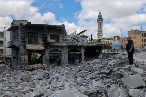 رجل ينظر إلى المباني المدمرة في أعقاب الغارات الإسرائيلية على السوق القديم التاريخي في بلدة النبطية بجنوب لبنان (إ.ب.أ)