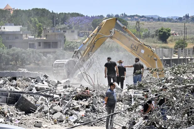 سكان عادوا إلى قريتهم يستخدمون حفارة للبحث عن مفقودين تحت أنقاض مبنى مدمر في قرية تولين جنوب لبنان 16 يونيو 2026 (إ.ب.أ)