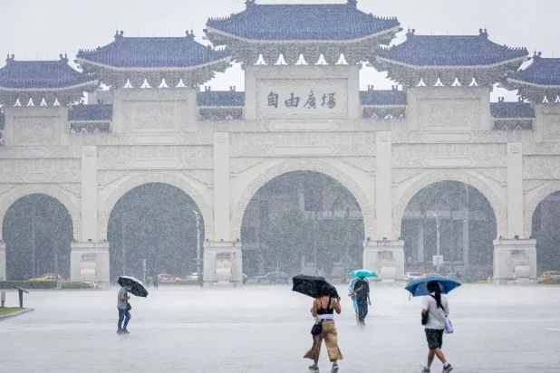 Pedestrians hold umbrellas as they walk amid rainfall during a vigil at Liberty Square in Taipei on June 4, 2026 to commemorate the anniversary of China's 1989 crackdown on pro-democracy protesters in Beijing's Tiananmen Square. (Photo by cheng-chia huang / AFP)