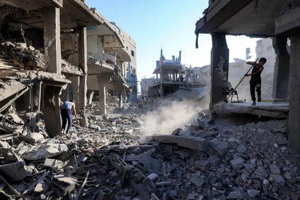 A boy sweeps through the rubble of a building that was destroyed following Israeli bombardment after an evacuation order, at the Maghazi camp for Palestinian refugees in the central Gaza Strip on June 12, 2026. (AFP)