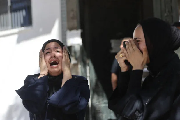 فلسطينيتان تصرخان خلال تشييع جنازة رجل قُتل في غارة إسرائيلية بمدينة غزة الخميس (أ.ف.ب)