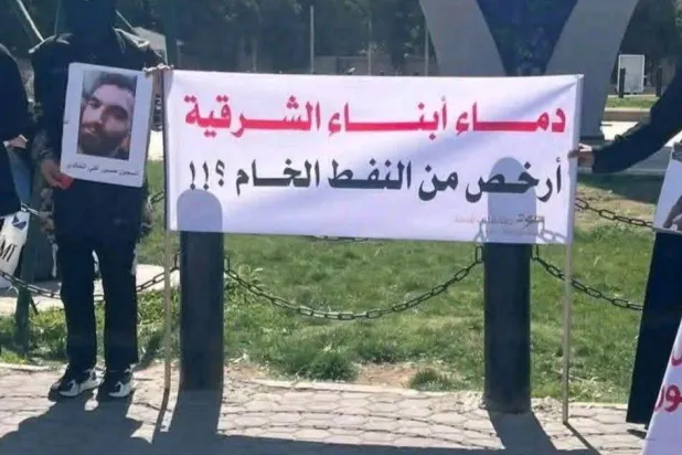 لافتة لأهالي المعتقلين المرحّلين إلى سجون العراق في اعتصام وسط دمشق (مرصد الحسكة)