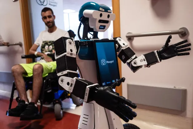 The humanoid robot Alter-Ego, designed by the Italian Institute of Technology, assists patient Daniel Senna through remote interaction at the IRCSS Maugeri hospital in Milan on June 12, 2026. (Photo by MARCO BERTORELLO / AFP)