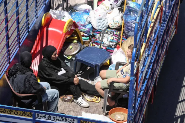 شاحنة تقل هاربين من الغارات الإسرائيلية على قرى الجنوب  اللبناني عند مدخل صيدا في طريقهم إلى بيروت أمس (أ.ف.ب) 