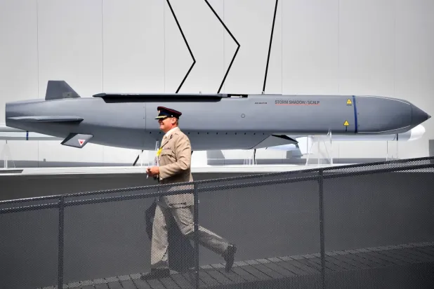 Londra'daki Farnborough Hava Gösterisi'nde bir İngiliz askerinin Storm Shadow füzesinin yanından geçerken, (Arşiv-AFP)