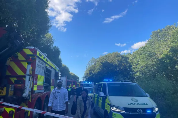 An injured man walks as emergency service workers gather near the scene of a collision involving two trains near Bedford, Britain, June 19, 2026. Picture taken with a mobile phone. Dr Pete Knapp/via REUTERS  