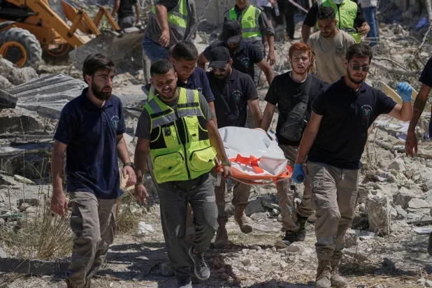 عمال انقاذ ينقلون ضحايا قتلوا بغارة اسرائيلية استهدفت بلدة قناريت بجنوب لبنان (أ.ب)