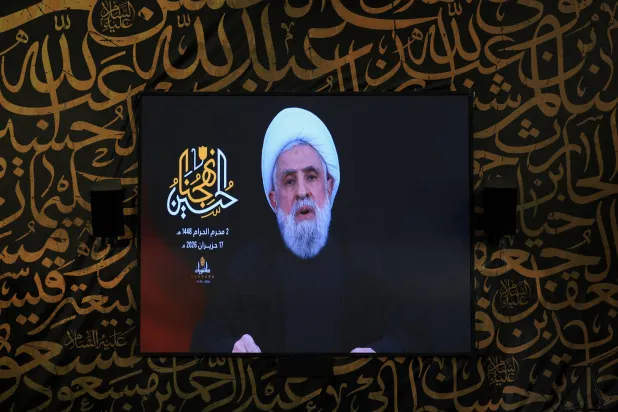 الأمين العام لـ«حزب الله» نعيم قاسم يلقي كلمة متلفزة على شاشة عملاقة في ضاحية بيروت الجنوبية (رويترز)