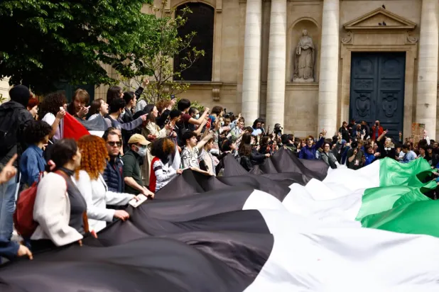 Gazze'ye destek veren öğrenciler, Nisan 2024'te Paris'teki Sorbonne Üniversitesi binası önünde oturma eylemi yaparken (EPA)