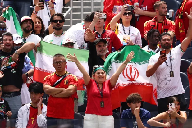 إيرانيون يساندون منتخب بلادهم خلال مباراة بلجيكا (رويترز)