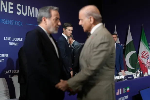 وزير الخارجية الإيراني عباس عراقجي أثناء مصافحته رئيس الوزراء الباكستاني شهباز شريف قبيل انطلاق الاجتماع الرباعي في منتجع بورغنشتوك السويسري (رويترز)