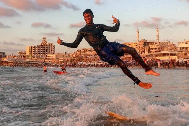 Surfers still ride the waves off Gaza City, despite the devastation wreaked on the Palestinian territory during the recent conflict. Omar AL-QATTAA / AFP
