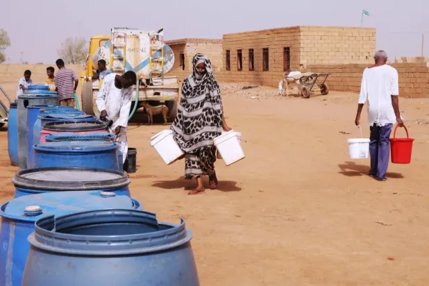 Sudan'ın Hartum kentinde su krizi yaşanırken, insanlar bir dağıtım noktasında su kaplarını dolduruyor, 18 Mayıs 2026 (AP)