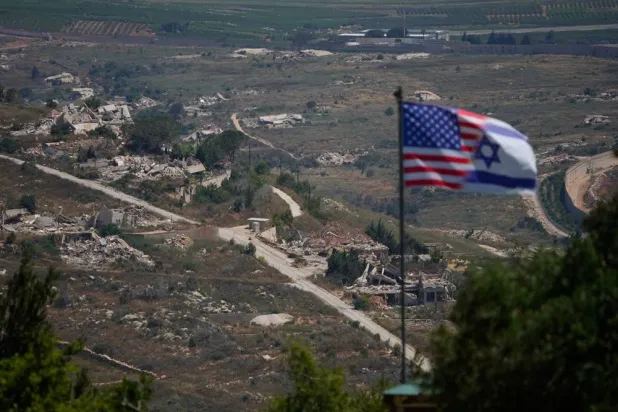 Israeli and US flags stand against a backdrop of destroyed buildings in southern Lebanon, as seen from northern Israel, Sunday, June 21, 2026. (AP) 