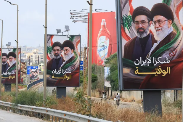 لافتات تحمل صور المرشد الإيراني مجتبى خامنئي ووالده علي خامنئي مرفقة بعبارة شكراً لإيران رفعت على طريق المطار باتجاه جنوب لبنان (رويترز)