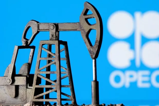 نموذج ثلاثي الأبعاد لمضخة استخراج نفط «Pump Jack» أمام شعار منظمة «أوبك» (رويترز)
