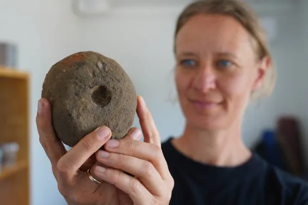  Moesgaard Museum archaeologist Liv Stidsing Reher-Langberg holds a Viking Age weight loom unearthed in Aarhus, Denmark, on June 22, 2026. (AP) 