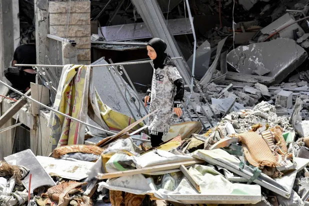 A woman inspects the rubble of a collapsed building in the town of Nabatieh al-Fawqa in southern Lebanon on June 23, 2026. (Photo by Fadel ITANI / AFP) 