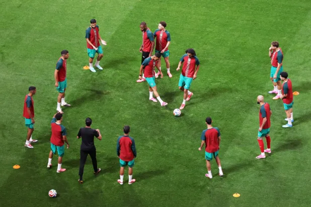لاعبو المغرب خلال تدريبات الإحماء (رويترز)