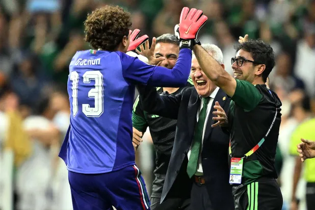 خافيير أغيري المدير الفني للمنتخب المكسيكي وتحية للحارس المخضرم أوتشوا (أ.ف.ب) 