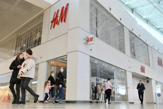 People walk past a closed H&M clothing store in Omsk, Russia, March 3, 2022. REUTERS/Alexey Malgavko