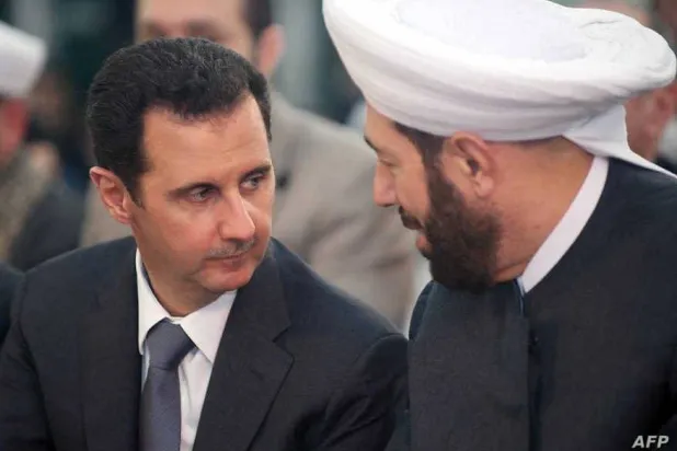 مفتي سوريا السابق مع الرئيس المخلوع بشار الأسد (أرشيفية)