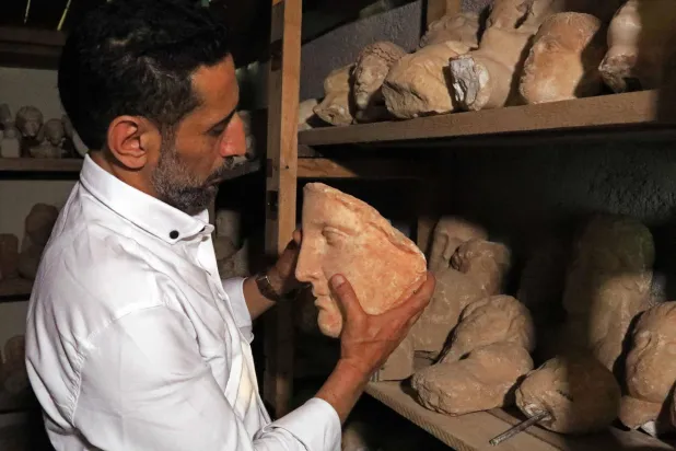 (FILES) A man holds a preserved artifact from the Cyrene archaeological site near the ancient historical town of Shahat in the northeastern Mediterranean coast of Libya on May 17, 2026. (Photo by Abdullah DOMA / AFP)
