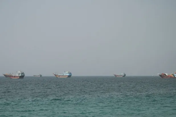 سفن في مضيق هرمز كما تظهر من مسندم في عُمان (رويترز)