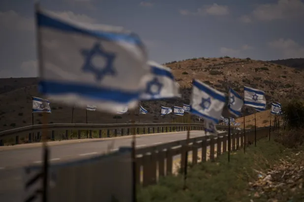 أعلام إسرائيلية على طريق شمال غور الأردن في الضفة الغربية... وثمة مخاوف في عمّان من ترحيل إسرائيل فلسطينيين إلى الضفة الشرقية لنهر الأردن (أ.ب)