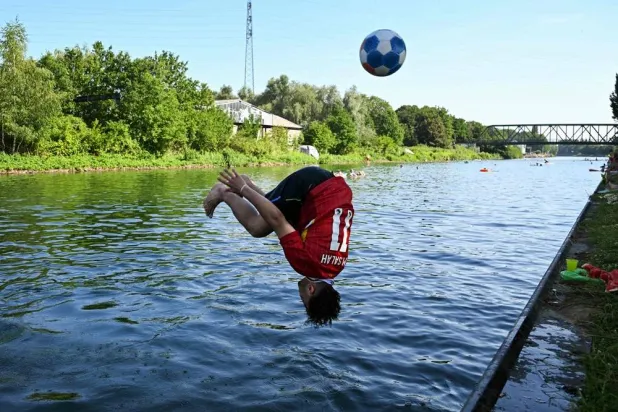 A boy jumps into the Dortmund-Ems Canal in Dortmund, western Germany on June 26, 2026 during a heatwave in Europe. (AFP)