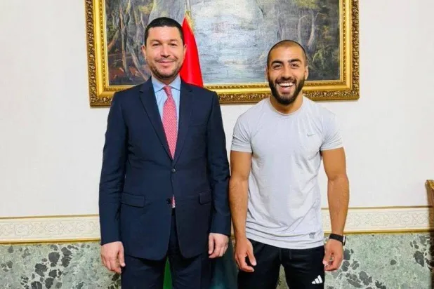 السفير الليبي لدى إيطاليا مع أحد المواطنين المفرج عنهم بمقر السفارة في روما الجمعة (صفحة السفارة)