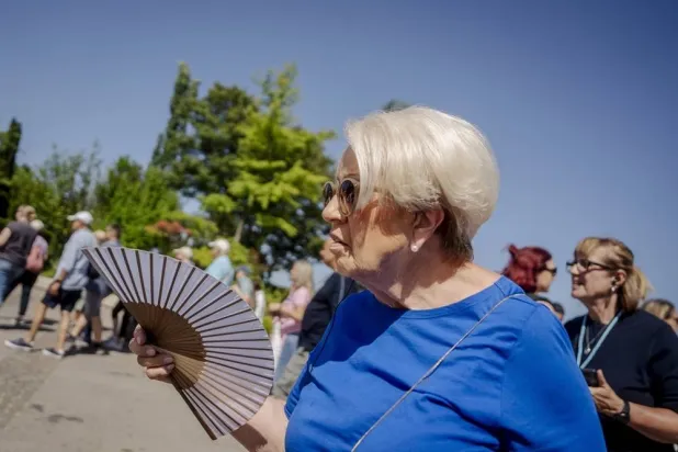 A woman uses a fan during the heatwave in Copenhagen, Denmark, 26 June 2026. (EPA)