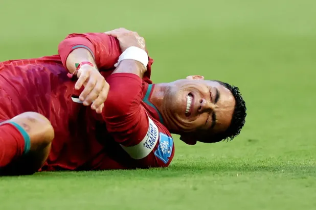 Portekiz Milli Takımı'nın kaptanı Cristiano Ronaldo, Kolombiyalı bir oyuncuyla girdiği ikili mücadele sonrası acı içinde yerde kaldı. (Reuters)
