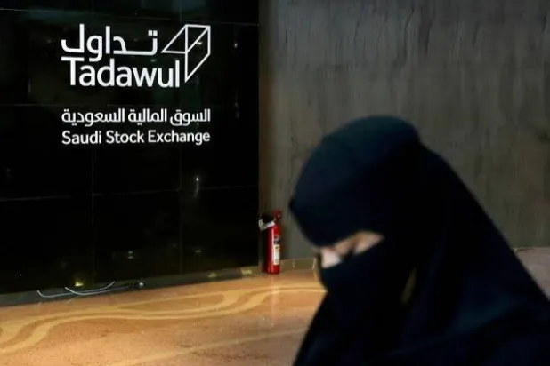 امرأة سعودية تمشي في السوق المالية السعودية (رويترز)