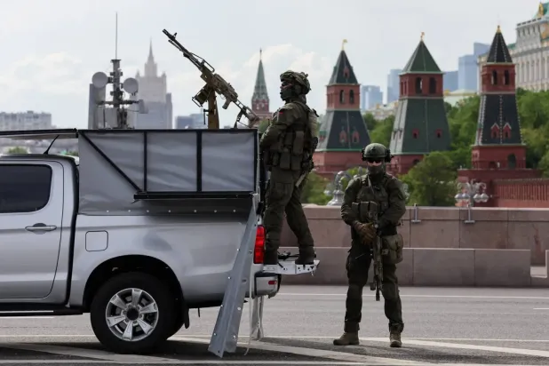 15 Mayıs 2026'da Moskova'nın merkezindeki Kremlin yakınlarında, makineli tüfekle donatılmış bir kamyonetin yanındaki Rus güvenlik görevlisi, (Reuters)