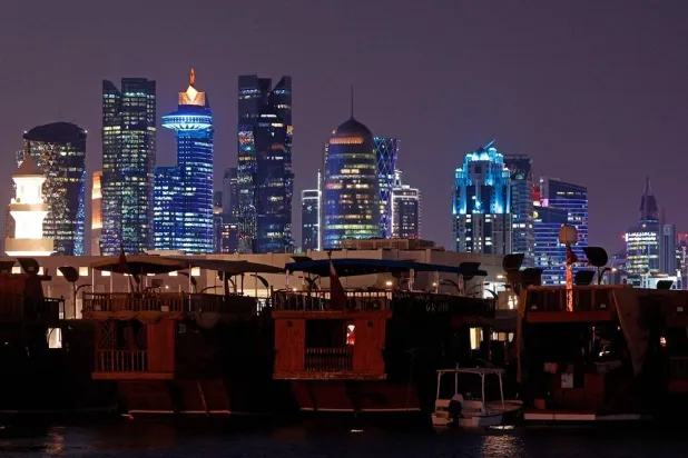 Illuminated skyscrapers are pictured along the corniche promenade in Doha on June 29, 2026. (AFP) 