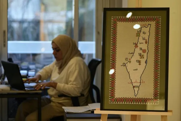 A hand-embroidered map of historic Palestine with names of cities and the words “Palestine” and “Returning” in Arabic is displayed at the Inaash Association embroidery workshop in Beirut, Tuesday, May 19, 2026. (AP) 