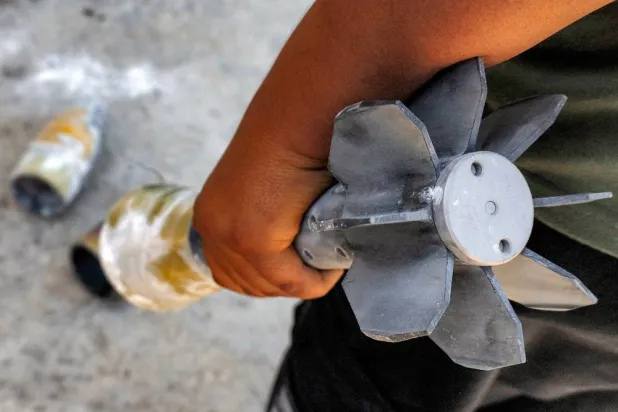 A man holds an unexploded artillery shell that fell during reported overnight Israeli bombardment that hit the village of Abidin in Syria's southwestern Daraa province, close to the Israeli-occupied Golan Heights, on June 29, 2026. (AFP)