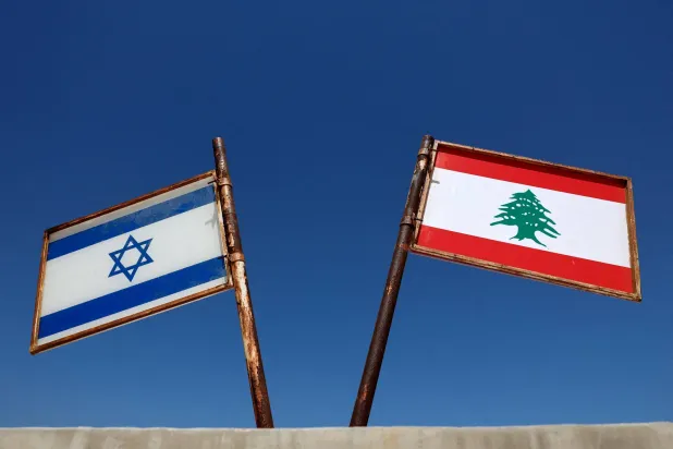 علما لبنان وإسرائيل مرفوعان في بلدة المطلة في شمال إسرائيل المحاذية للحدود اللبنانية (رويترز)