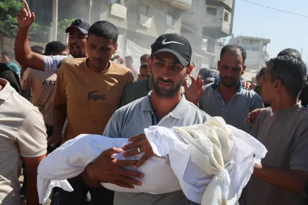 فلسطينيون يشيِّعون رضيعة قُتلت مع أمها بغارة إسرائيلية في خان يونس جنوب غزة (رويترز)