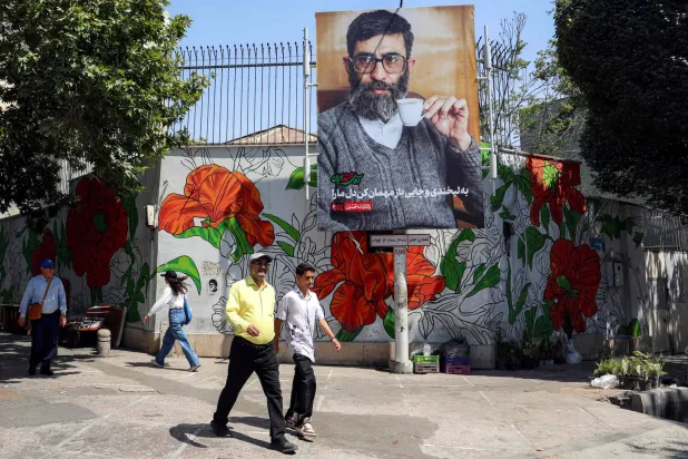 مارة أمام لوحة نعي لعلي خامنئي في طهران الثلاثاء قبل مراسم تشييعه المقررة في 4 يوليو (أ.ف.ب)