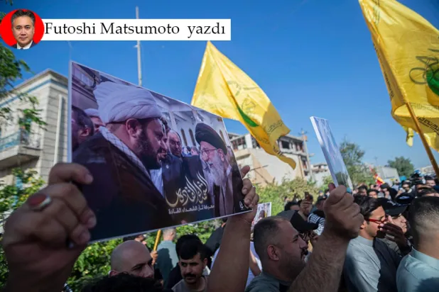 Irak’ın başkenti Bağdat'ta düzenlenen Ekrem el-Kaabi ile dayanışma gösterisinde İran Dini Lideri Ali Hamaney ile İran yanlısı silahlı grup Nuceba Hareketi Genel Sekreteri Ekrem el-Kaabi'nin fotoğraflarının yer aldığı pankartı taşıyan bir kişi, 8 Mayıs 2026 (Reuters)