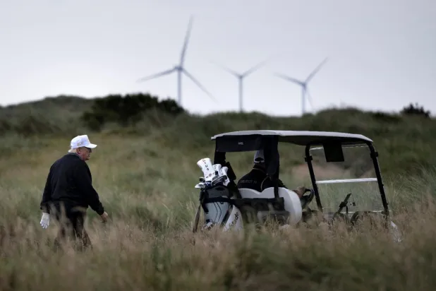 İskoçya'nın Aberdeenshire kentindeki golf sahasında görülen Donald Trump'ın rüzgar santrallerini sert bir şekilde eleştirdiği biliniyor (AFP)