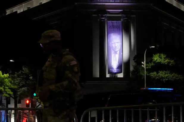 Başkan Donald Trump'ın resminin bulunduğu pankart, Washington DC'deki Robert F. Kennedy Adalet Bakanlığı binasının dış cephesinde ışıklandırılmış halde duruyor. Adalet Bakanlığı'nın, pankartların üretimi ve montajı da dahil binanın dış cephe iyileştirmeleri için yaklaşık 1 milyon dolar harcadığı bildirildi (Reuters)